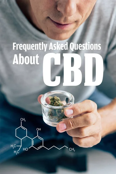 Cropped view of man in t-shirt looking at medical cannabis in glass container with frequently asked questions about cbd illustration — Stock Photo