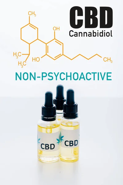 Cbd oil in bottles isolated on white with non-psychoactive cbd illustration — Stock Photo