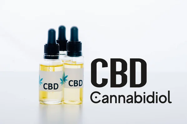 Aceite de cbd en botellas aisladas en blanco con ilustración cbd - foto de stock