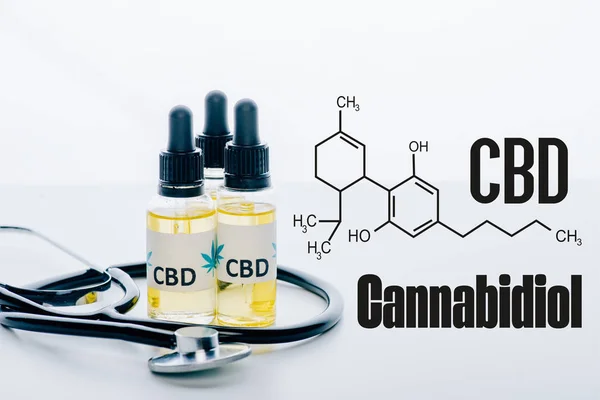 Olio di cbd in bottiglie e stetoscopio isolato su bianco con illustrazione della molecola di cbd — Foto stock