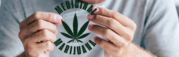 Panoramic shot of man rolling blunt near medical marijuana illustration — Stock Photo
