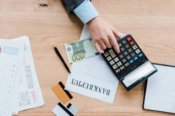 Top view of businessman using calculator near euro banknote and credit cards — Stock Photo