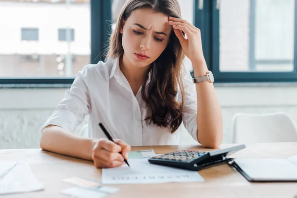 Frustré document de signature femme d'affaires près de la calculatrice — Photo de stock