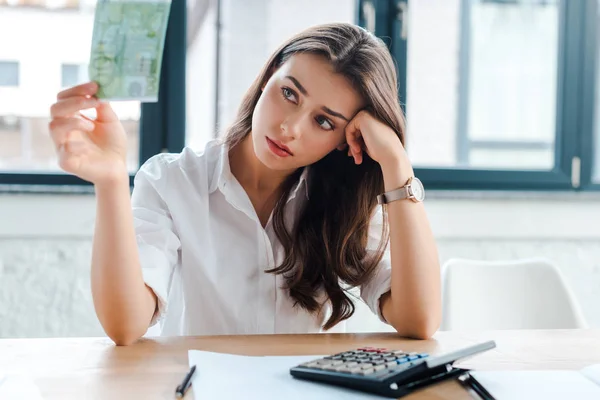 Enfoque selectivo de la mujer molesta que mira el billete en euros en el cargo — Stock Photo