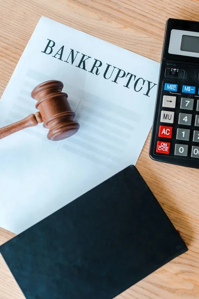 Top view of paper with bankruptcy letters near calculator and gavel — Stock Photo