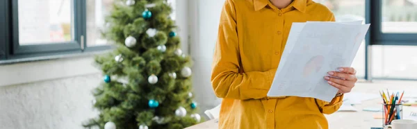 Panoramic shot of woman holding paper near decorated christmas tree — Stock Photo