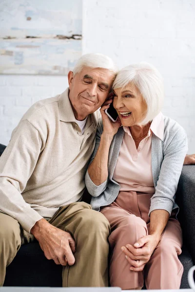 Mann und lächelnde Frau unterhalten sich in Wohnung auf Smartphone — Stockfoto