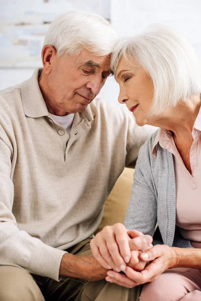 Handsome husband and attractive wife holding hands in apartment — Stock Photo