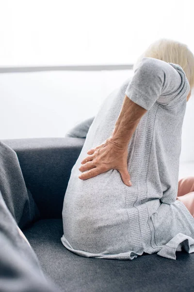 Back view of senior woman having back pain in apartment — Stock Photo