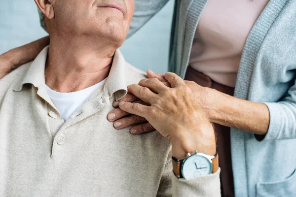 Vista ritagliata di marito e moglie che si tengono per mano in appartamento — Foto stock