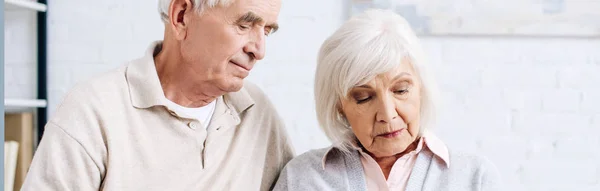 Panoramic shot of husband and wife looking down in apartment — Stock Photo