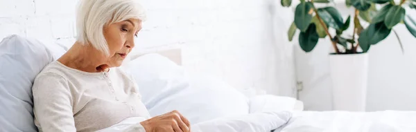 Colpo panoramico di donna attraente e anziana a letto — Foto stock