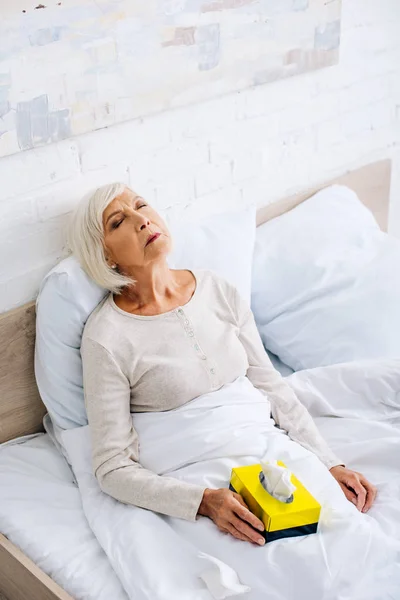 Vista ad alto angolo di malata donna anziana con gli occhi chiusi a letto — Foto stock