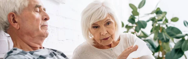 Plan panoramique du mari et de la femme regardant la serviette dans l'appartement — Photo de stock