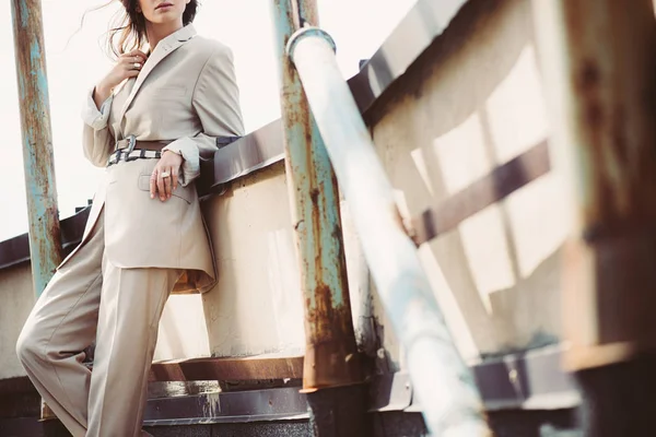 Cropped view of stylish girl posing in beige suit on urban roof — Stock Photo