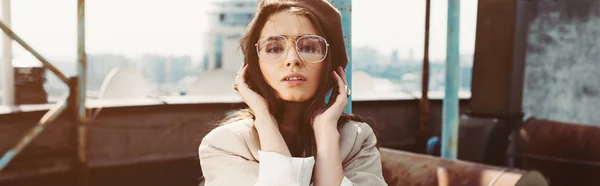 Attractive elegant girl posing in beige suit and beret on roof — Stock Photo