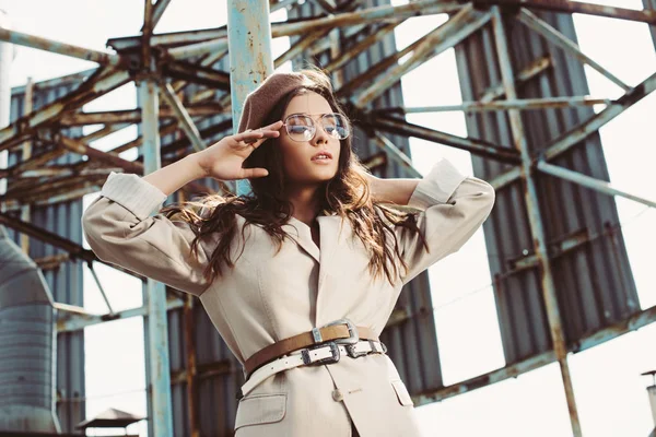 Attractive fashionable girl posing in beige suit and beret on roof — Stock Photo