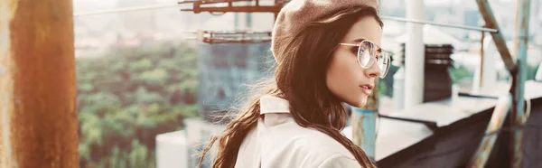 Fashionable model posing in beige suit and beret on urban roof — Stock Photo