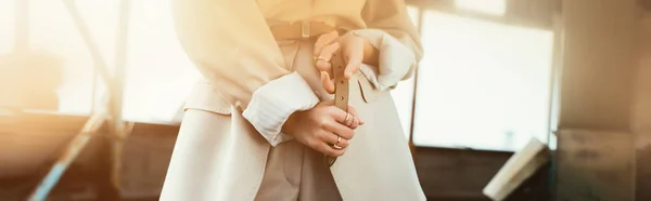 Abgeschnittene Ansicht einer modischen eleganten Frau, die im beigen Anzug auf einem städtischen Dach posiert — Stockfoto