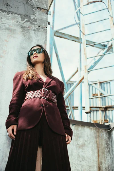 Beautiful elegant model posing in trendy burgundy suit on urban roof — Stock Photo