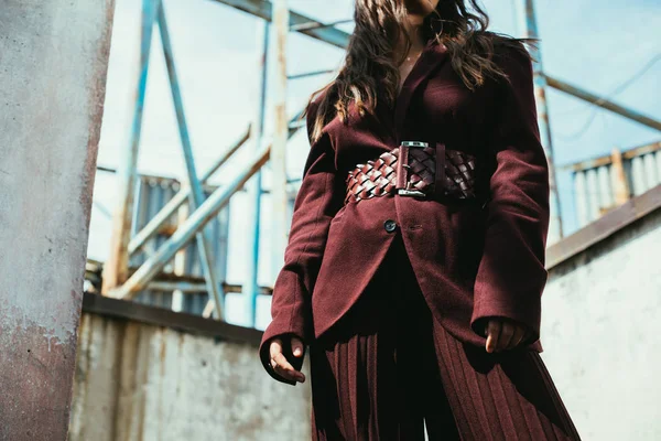 Vista cortada de menina elegante posando em terno borgonha na moda no telhado urbano — Fotografia de Stock