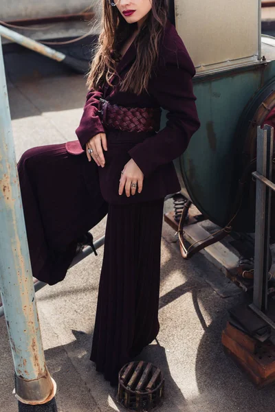 Cropped view of stylish girl posing in trendy burgundy suit on urban roof — Stock Photo