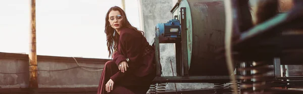 Stylish elegant girl posing in trendy burgundy suit and sunglasses on urban roof — Stock Photo