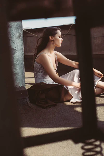 Atraente mulher elegante posando em vestido de seda e casaco marrom no telhado — Fotografia de Stock