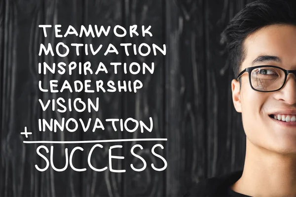 Cropped view of smiling asian man in glasses and illustration with concept words of success — Stock Photo