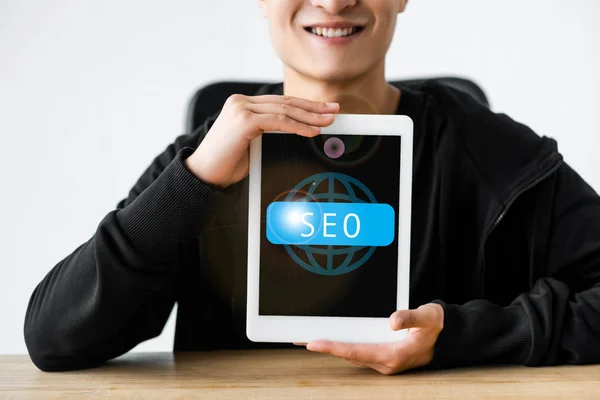 Vista ritagliata di sorridente seo manager in possesso di tablet digitale con e-mail marketing lettering — Foto stock