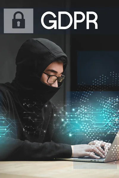 Азиатский хакер с помощью ноутбука и сидя возле навесной иллюстрации и gdpr буквы — стоковое фото