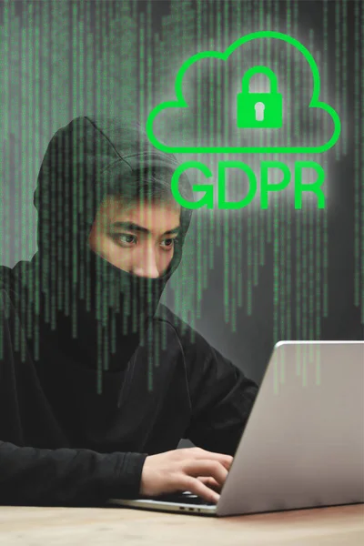 Hacker asiático usando el ordenador portátil y sentado cerca de candado ilustración y gdpr letras - foto de stock