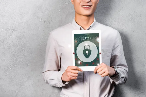 Recortado vista de sonriente hombre de negocios sosteniendo tableta digital con ilustración gdpr — Stock Photo
