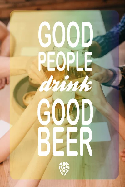 Cropped view of multicultural friends clinking glasses with beer in pub with good people drink good beer illustration — Stock Photo