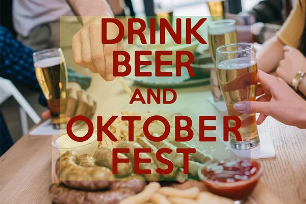 Vista recortada de amigos bebiendo cerveza y comiendo bocadillos en el pub con cerveza de bebida y Oktoberfest ilustración - foto de stock