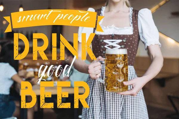 Vista parziale della cameriera in costume nazionale tedesco in possesso di tazza di birra leggera vicino a persone intelligenti bere buona illustrazione birra — Foto stock