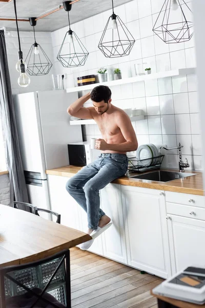 Homem sem camisa segurando xícara de café na cozinha de manhã — Fotografia de Stock