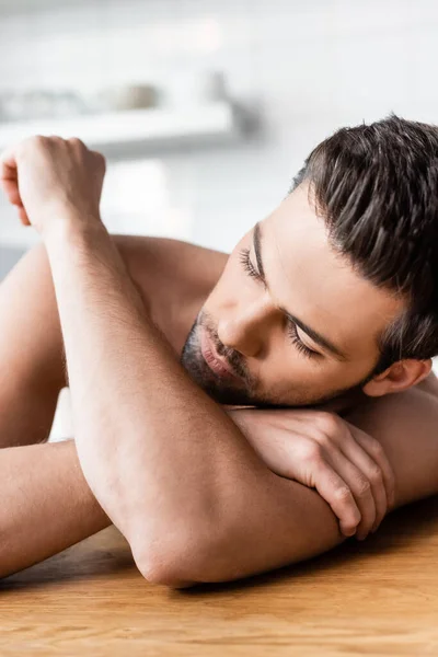 Handsome shirtless sexy man lying on kitchen — Stock Photo