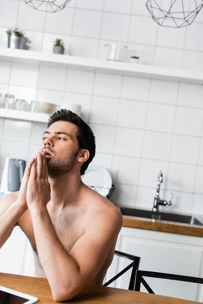 Thoughtful handsome shirtless man using digital tablet on kitchen — Stock Photo