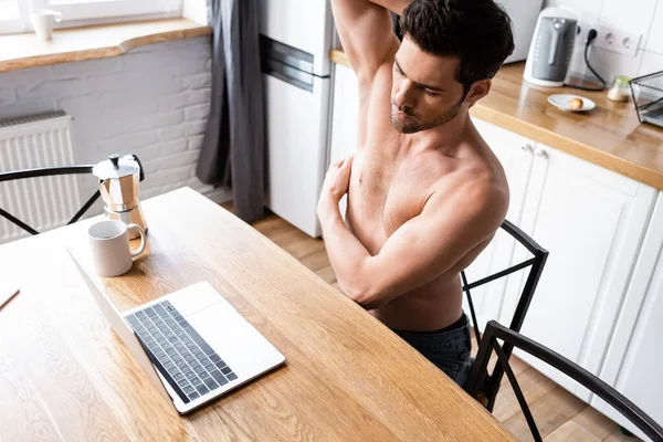 Freelancer sem camisa sexy trabalhando no laptop na cozinha com café — Fotografia de Stock
