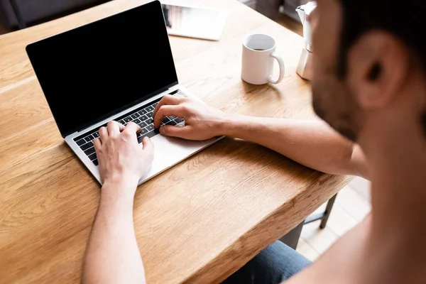 Vue recadrée de freelance masculin travaillant sur ordinateur portable avec écran blanc — Photo de stock