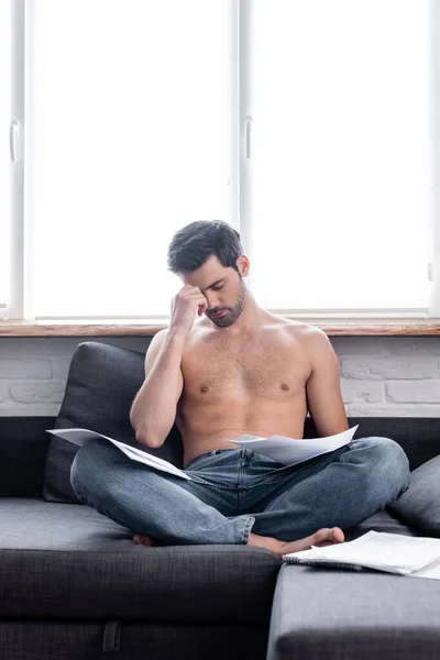 Besorgte freie Mitarbeiterin, die während der Quarantäne auf dem Sofa mit Dokumenten arbeitet — Stockfoto