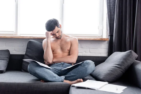 Sexy estresado freelancer trabajando con documentos en el sofá durante el autoaislamiento - foto de stock