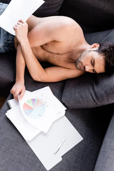 Freelancer sexy dormindo com gráficos e documentos no sofá durante a quarentena — Fotografia de Stock