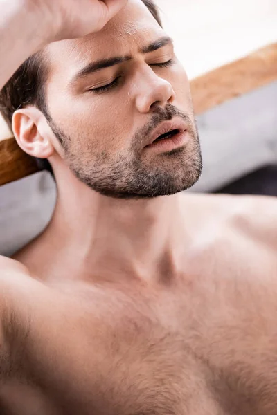 Sexy shirtless man with closed eyes suffering from heat at home — Stock Photo