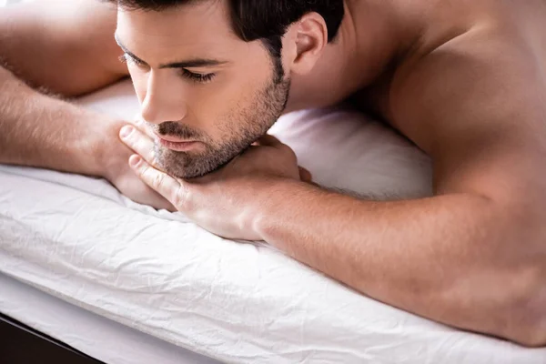 Handsome pensive man lying on bed at home — Stock Photo