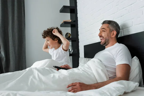 Enfoque selectivo de alegre padre e hijo viendo la película - foto de stock