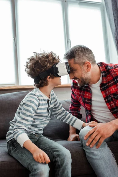 Happy father near curly son in virtual reality headset — Stock Photo