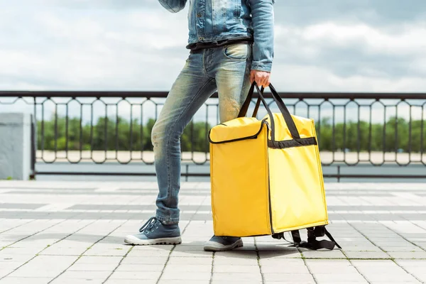 Vue recadrée du livreur tenant un sac thermique dans une rue urbaine — Photo de stock