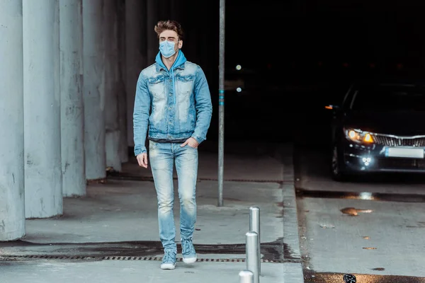 Selective focus of man in medical mask walking near road — Stock Photo